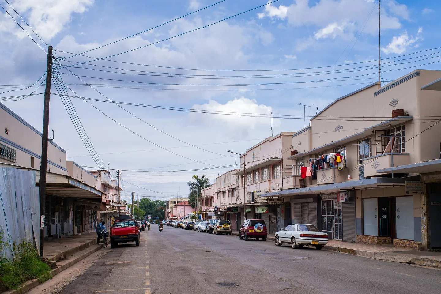Mtaa wenye maduka na magari yaliyoegeshwa Arusha.